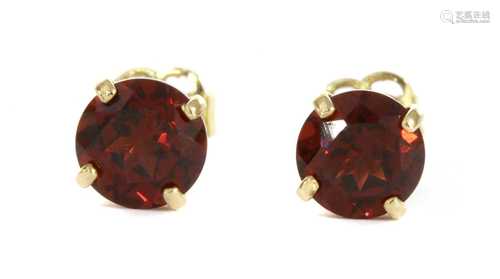 A pair of gold single stone garnet stud earrings,