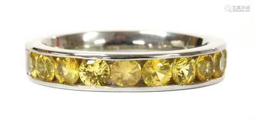 A platinum yellow sapphire half eternity ring,