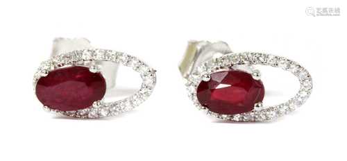 A pair of white gold ruby and diamond halo stud earrings,