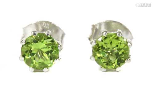 A pair of white gold single stone peridot stud earrings,