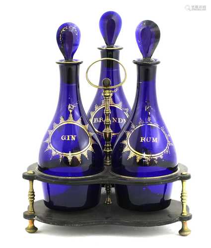 An ebonised decanter stand and three 'Bristol' blue glass de...