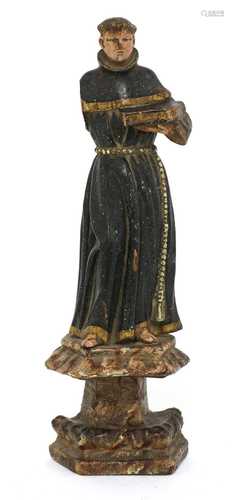 A carved wooden and painted figure of a monk,