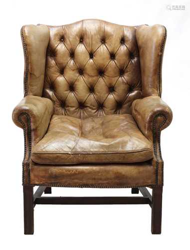 A George III-style buttoned leather wingback armchair,