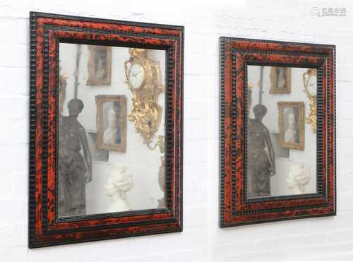 Two similar red tortoiseshell and ebonised wall mirrors,