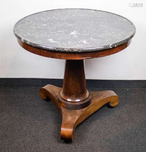 A round table with marble top on a central feet