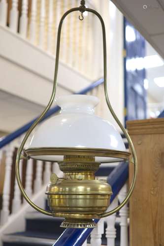 A Victorian brass hanging oil lamp, with a white opaque glas...