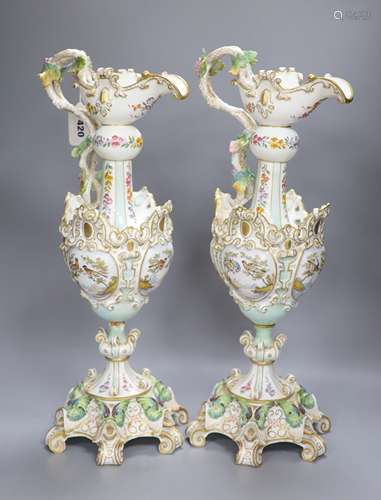 A pair of 19th century German floral and bird painted ewers,...