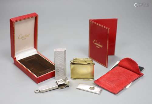 A cased Must de Cartier lighter, one other and two cigar cut...