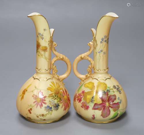 A pair of Royal Worcester blush ivory ewers painted and gild...