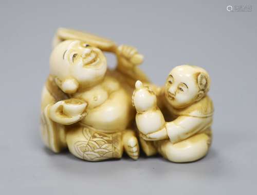 A Japanese ivory netsuke in the form of a seated Hotei and a...