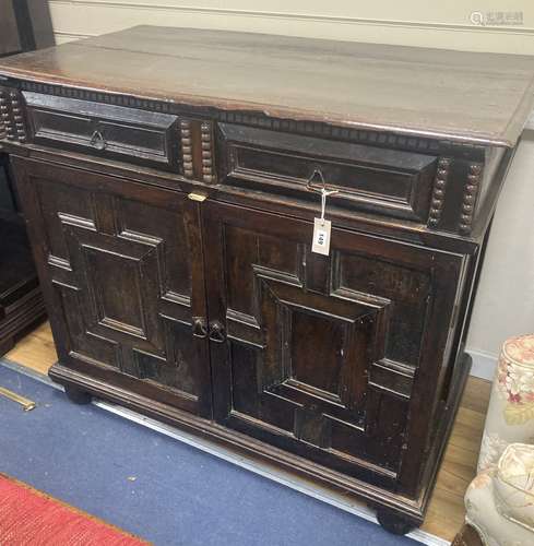 A Jacobean oak cupboard, fitted with a pair of doors, width ...