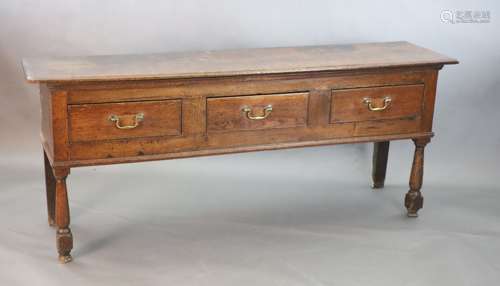 A mid 18th century oak three drawer low dresser, raised on t...