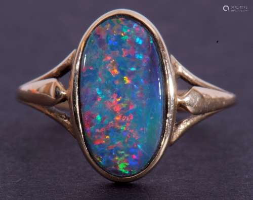 9ct gold and opal ring, the oval shaped opal doublet in rub-...