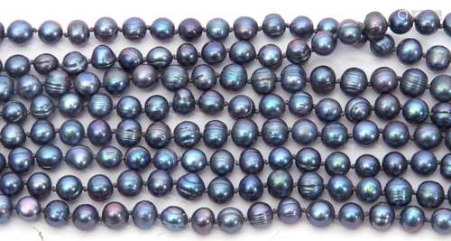 Long continuous row of dyed dark grey pearls with green and ...