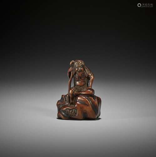 GYOKURINTEI: A WOOD NETSUKE OF TEKKAI SENNIN SEATED ON A ROC...