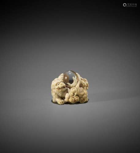 KAGETOSHI: AN IVORY NETSUKE OF TWO SHISHI WITH ROCK CRYSTAL ...