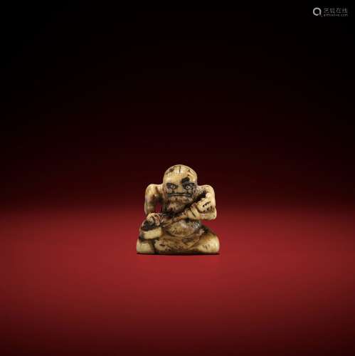 AN EARLY STAG ANTLER NETSUKE OF AN ONI PLAYING THE SAMISEN