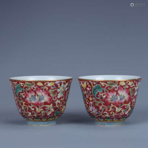 A pair of famille rose cups with lotus pattern on red ground...