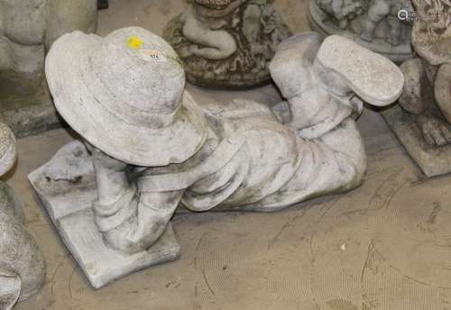 A cast composite stone garden statue of a reading child,