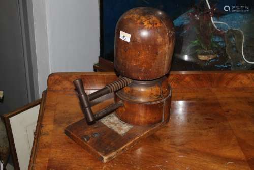 An early 20th century stained beech wood and steel hat press...