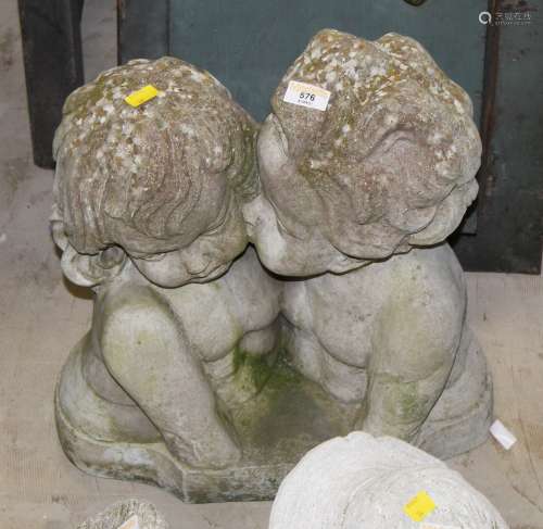 A cast composite stone garden statue, two children embracing...
