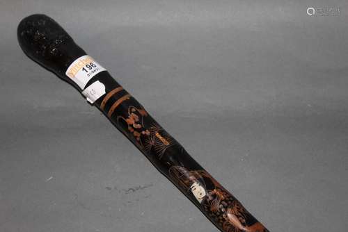 A Japanese ebonised walking stick, carved and inlaid in bone...