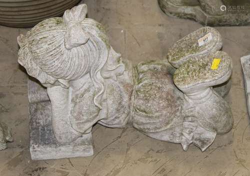 A cast composite stone garden statue of a young girl reading...