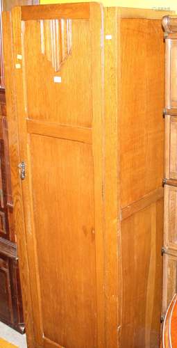 A 1920's panelled oak single wardrobe with linen fold motif ...