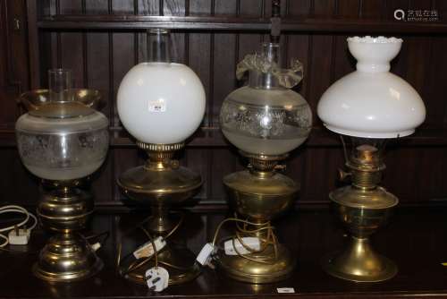 Four brass table oil lamps (two converted to electricity & o...