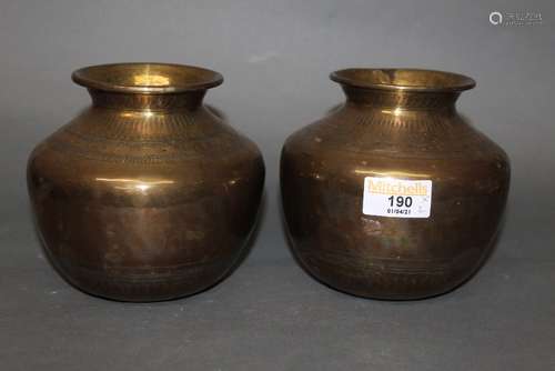 A pair of near Eastern brass bulbous vases engraved with flo...