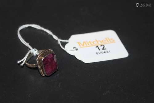 A silver and pink hard stone ring with faceted baguette cut ...