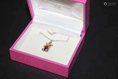 A gold coloured metal and amethyst teddy bear pendant neckla...