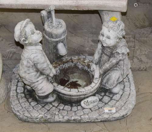 A cast composite stone garden statue of two children by a wa...