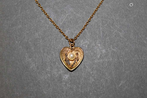 A gold coloured metal filigree heart pendant with cultured s...