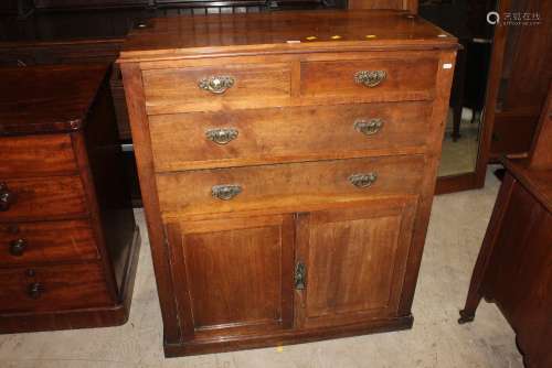 An Edwardian oak cupboard fitted four drawers,