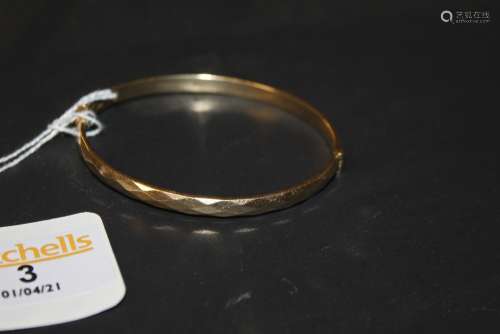 A 19ct rose gold bangle of faceted design, 6.