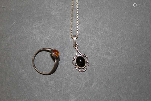 A silver and jet pendant with oval cabochon stone and chain ...