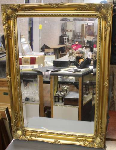 A reproduction rectangular gilt framed and bevelled wall mir...