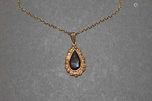 A 9ct gold and hematite pendant with cast leaf scroll border...