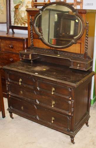 A 1920's dark oak dressing chest with oval mirror, spiral tu...