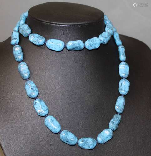 A blue hard stone graduated bead necklace with gilt metal sc...