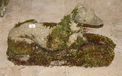 A concrete garden ornament modelled as a recumbent dog,