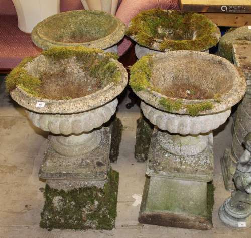 A set of four concrete campana urns each 46 cm diameter on s...