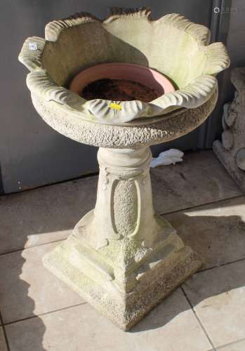 A cast composite stone pedestal urn, of Arts and Crafts desi...