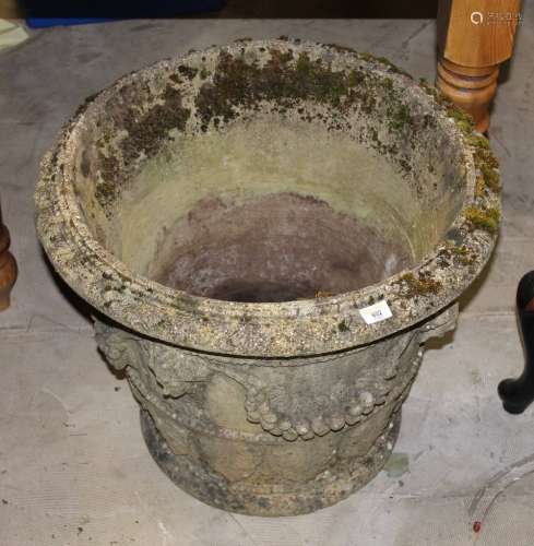 A large concrete cylindrical garden urn with tapered sides,