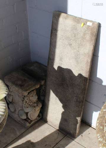 A cast composite stone garden bench, the oblong top raised o...