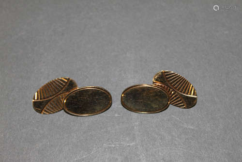 A pair of 9ct gold cuff links with engraved oval faces,