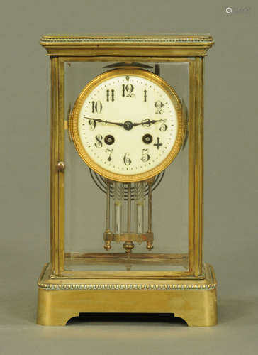 A late Victorian brass four glass library clock,