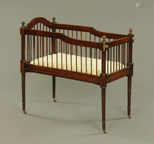 An Edwardian child's mahogany crib, with spindle turned side...