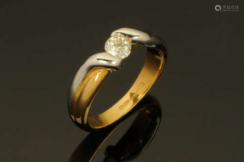 An 18 ct two tone gold twist ring, semi-tension set with a d...